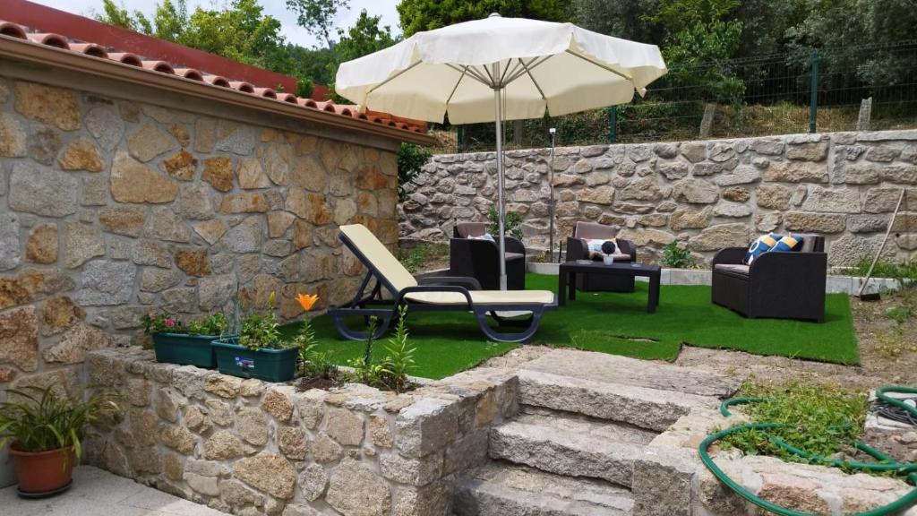 的住宿－Casa dos Devezas，庭院里设有带椅子和遮阳伞的庭院。