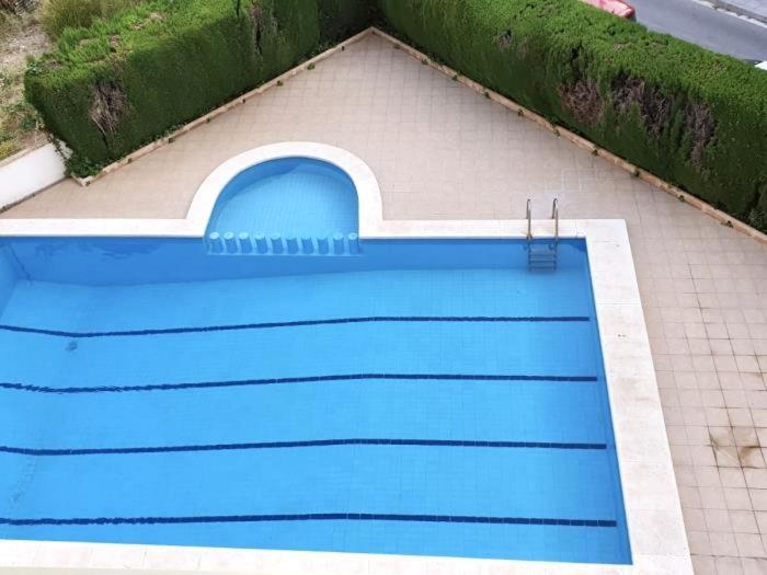 a blue swimming pool on the side of a house at APARTBEACH SANCHO ABARCA CENTRICO y JUNTO PLAYA in Salou