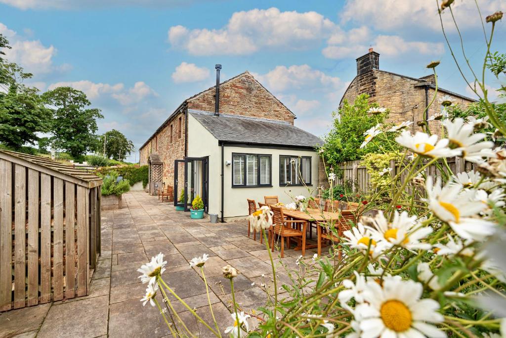 uma vista exterior do chalé com mesas e cadeiras em Finest Retreats - Quarry Lodge em Wigton