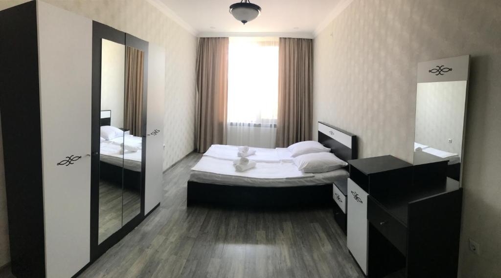 małą sypialnię z łóżkiem i lustrem w obiekcie Friendly House w Achalciche