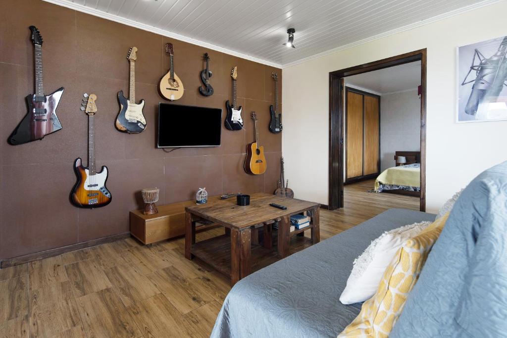 a living room with guitars hanging on the wall at Alojamento do Rosário in Lagoa