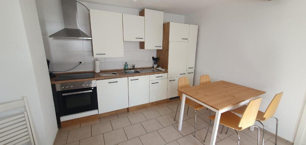 a kitchen with white cabinets and a wooden table at Zum Edelhof 