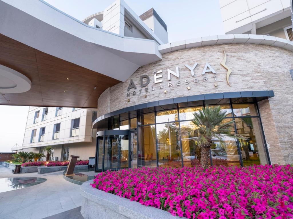 budynek z różowymi kwiatami przed nim w obiekcie Adenya Hotel & Resort Halal All Inclusive w Avsallarze