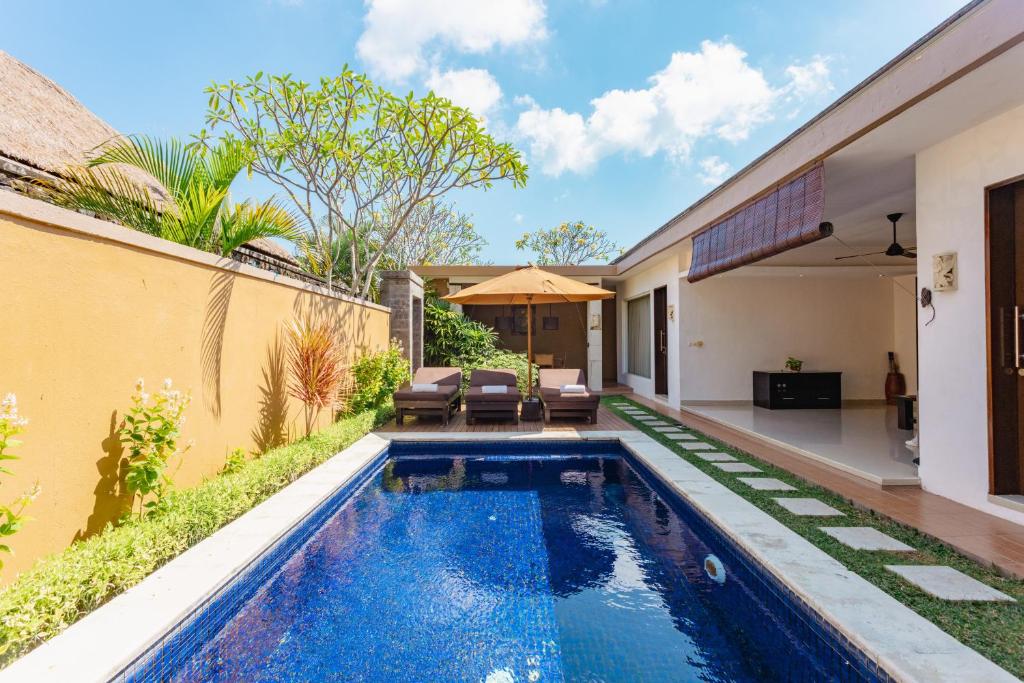 a swimming pool in the backyard of a house at The Yubi Boutique Villas Seminyak - CHSE Certified in Seminyak