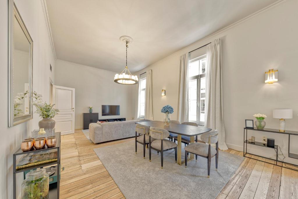 uma sala de estar com uma mesa e cadeiras e um sofá em Appartement dans l'hypercentre em Bruxelas