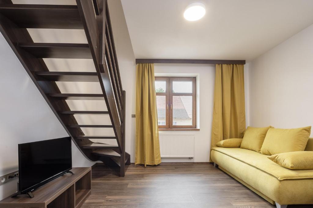 a living room with a couch and a tv at Hotel Grand in Doksy