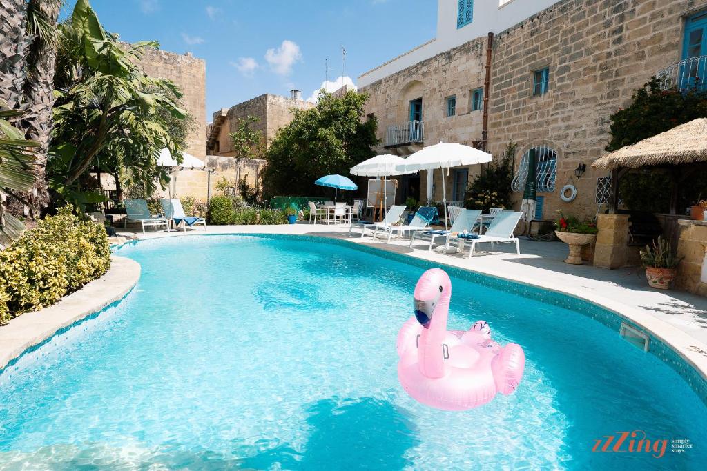 un flamenco rosa inflable en una piscina en Rest, restore, explore. An exclusive stay in Malta, en Żebbuġ