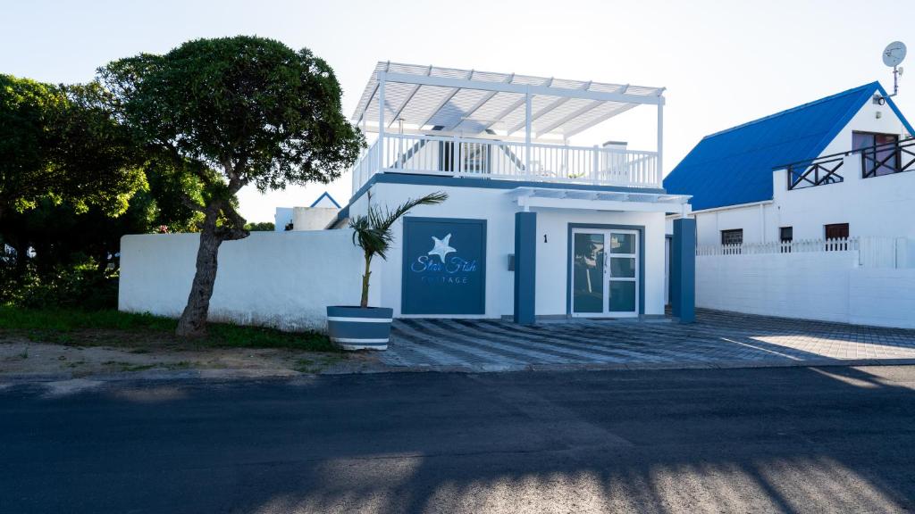 Biały dom z doniczką przed nim w obiekcie Starfish Cottage, Langebaan w mieście Langebaan