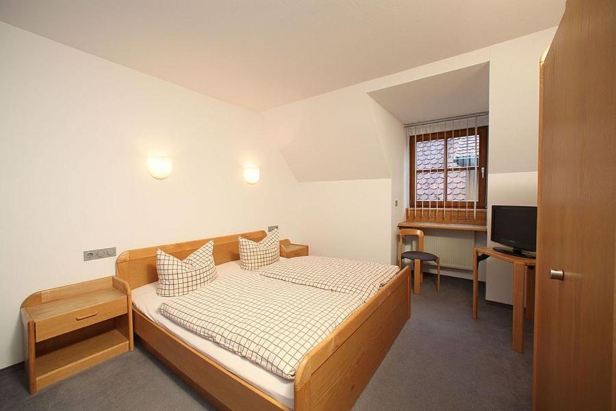 Schlafzimmer mit einem Bett, einem Schreibtisch und einem TV in der Unterkunft Gasthof zum Bayerischen in Greding