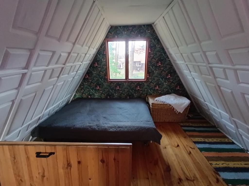 a small room with a bed and a window at Czekoladowy Domek in Nadkole