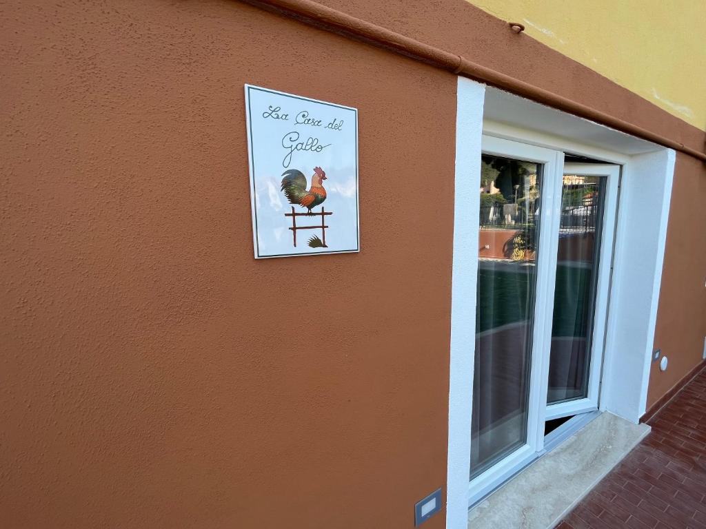 a sign for a chicken on the side of a building at La casa del Gallo in Pietra Ligure