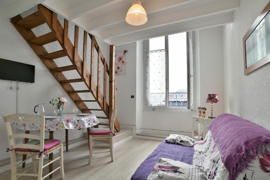 - une chambre avec un lit violet et une table dans l'établissement Le Sillon - Appartement proche de la plage, à Saint-Malo
