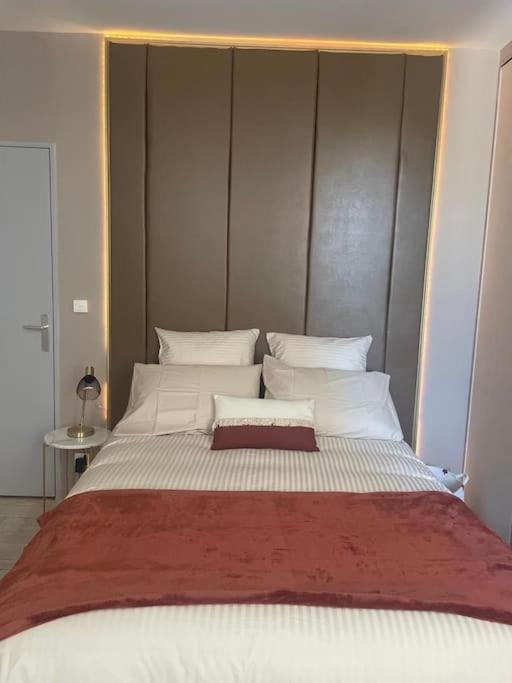 ein Schlafzimmer mit einem großen Bett mit weißen Kissen in der Unterkunft Appartement style hôtel cocooning in Limoges