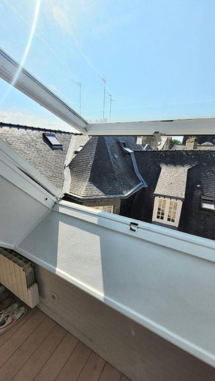 a window on a roof with a view of a house at Studio Design Sous Toits IntraMuros Vue Cathédrale in Vannes