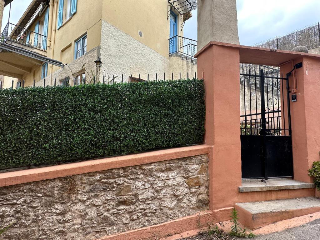 a building with a stone wall next to a gate at La maison de Giulia Menton in Menton