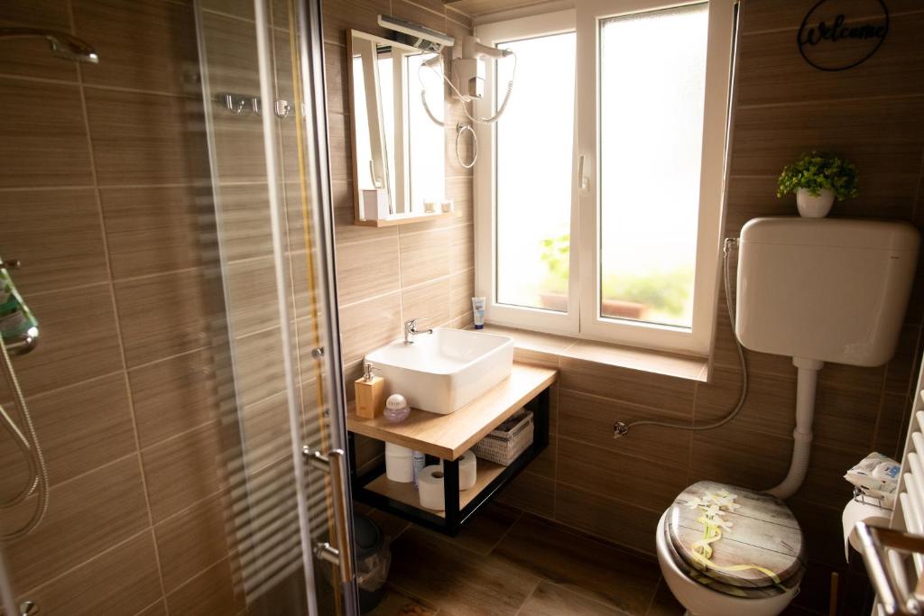 baño con lavabo y ventana en KONAK, en Pleternica