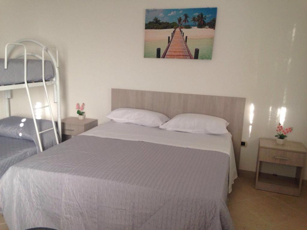 sypialnia z dużym łóżkiem z białą pościelą w obiekcie Sal y Mar w mieście Torre San Giovanni Ugento