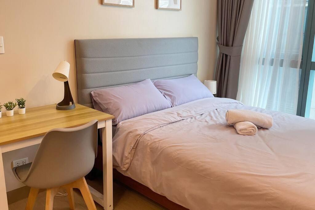 - une chambre avec un lit, un bureau et une chaise dans l'établissement Cozy 1 BR One Uptown Residences BGC, à Manille