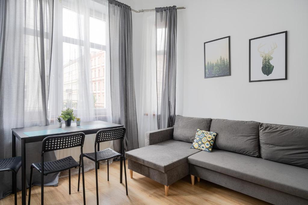 a living room with a couch and a table and chairs at RentPlanet - Studio Żeromskiego in Wrocław