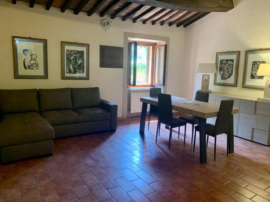 sala de estar con sofá, mesa y sillas en Caratteristico appartamento nel borgo medievale en Castiglione della Pescaia