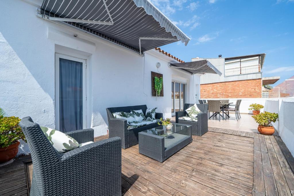 een patio met stoelen en een tafel op een houten terras bij Cambrils Turistic Atico in Cambrils