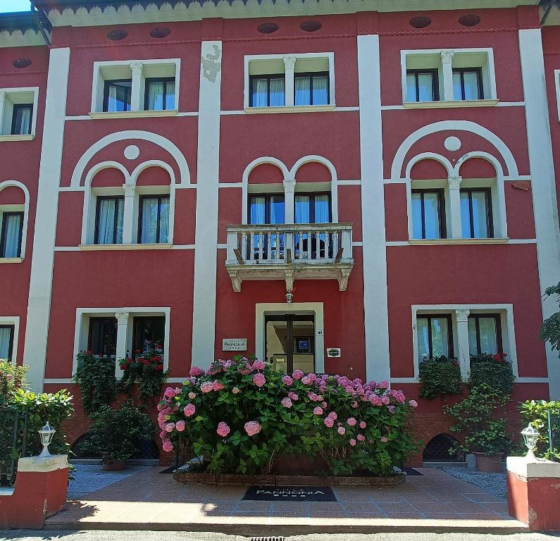 a red building with flowers in front of it at Hotel Villa Pannonia in Venice-Lido