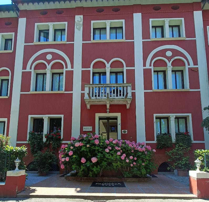 um edifício vermelho com flores em frente em Hotel Villa Pannonia em Lido di Venezia