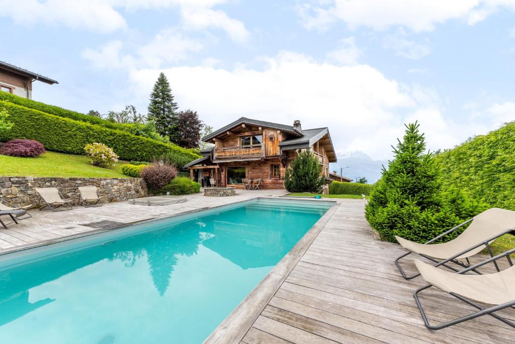 a home with a swimming pool and a house at Chalet Victoria - Magnifique chalet avec piscine privée in Saint-Gervais-les-Bains