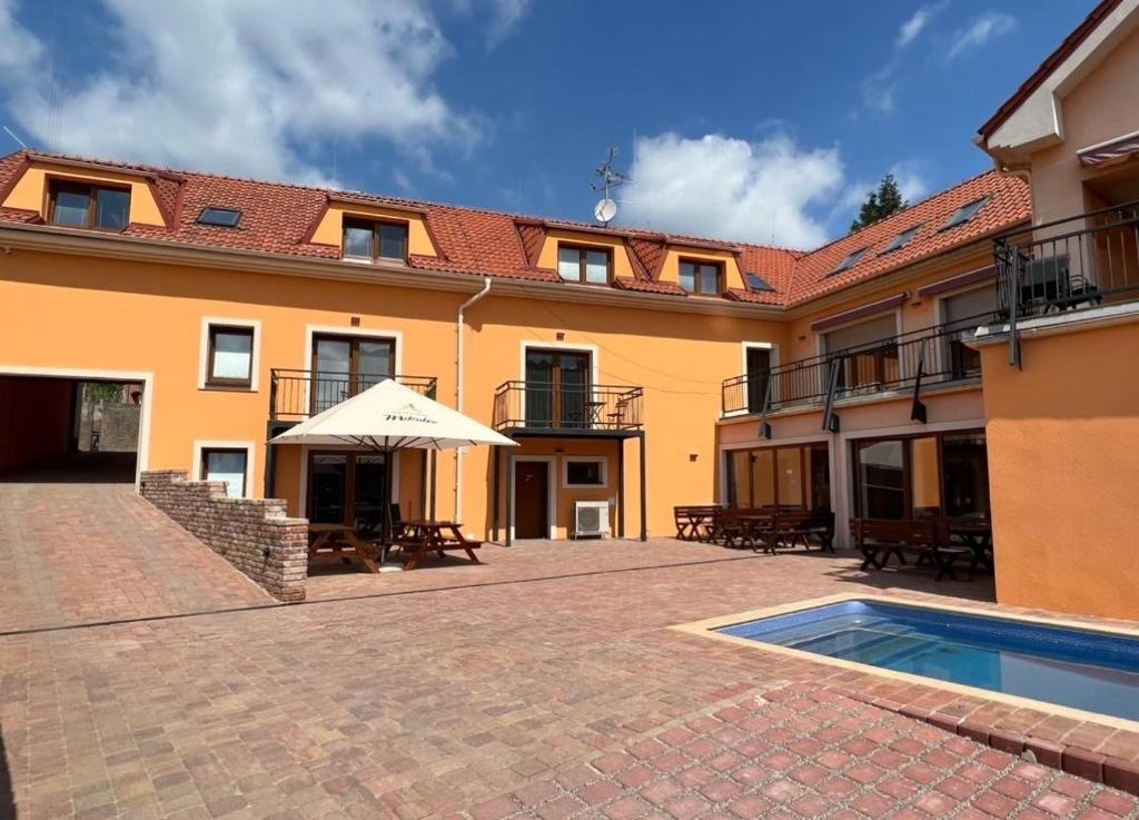 ein Gebäude mit einer Terrasse und einem Pool in der Unterkunft Pension Mikulov in Mikulov