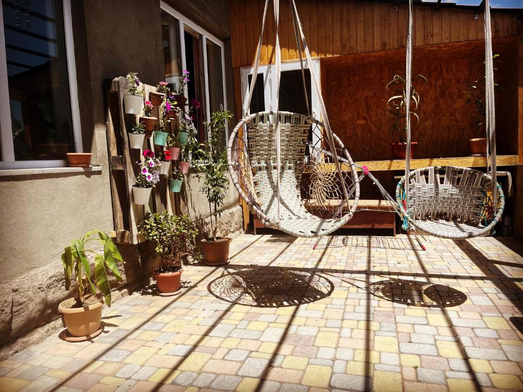 een patio met potplanten en een schommel bij Lake Sevan Hostel in Sevan