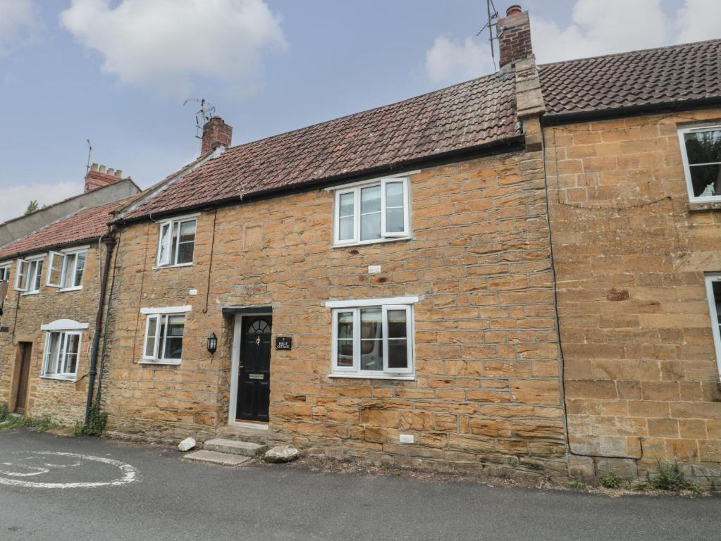 an old brick house on the side of a street at Holly Cottage in Yeovil