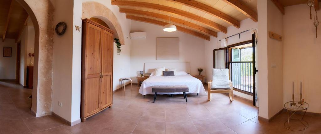 sypialnia z białym łóżkiem, stołem i krzesłami w obiekcie Ses cases noves Llucmajor w mieście Llucmajor