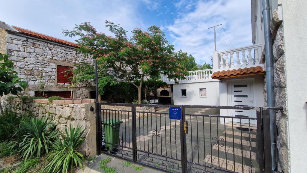 een poort voor een wit huis bij Lukari Vacation Home in Drivenik