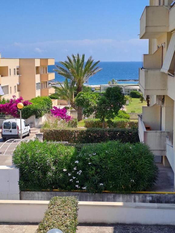 uma vista para um edifício com o oceano ao fundo em Hotel La Punta em Otranto