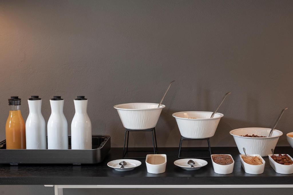 a group of white vases and bowls on a table at ANEMI Folegandros in Karavostasi