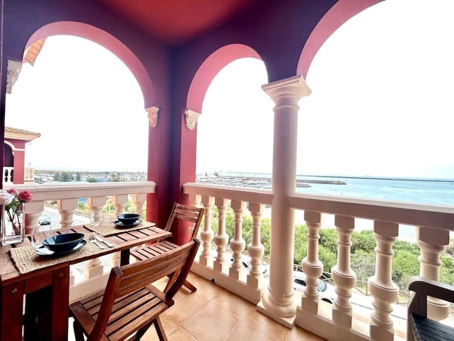 comedor con balcón con mesa y sillas en Hispalis Mazagón Beach 304, en Mazagón