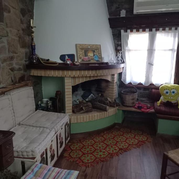 a living room with a fireplace and a couch at Παραδοσιακό πέτρινο σπίτι in Volissos