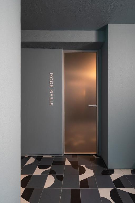a elevator door in a room with a checkered floor at ANEMI Folegandros in Karavostasi