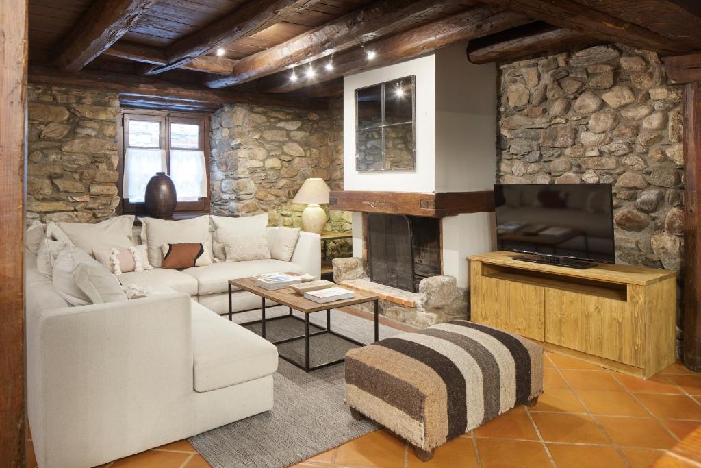 a living room with a white couch and a fireplace at Casa Montarto by FeelFree Rentals in Arties
