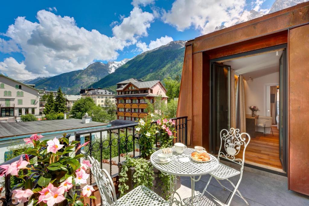夏慕尼白朗峰的住宿－格蘭德酒店，设有一个配有桌椅并享有美景的阳台。