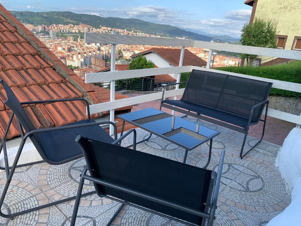 a patio with chairs and a table on a roof at Caramelo in Bilbao