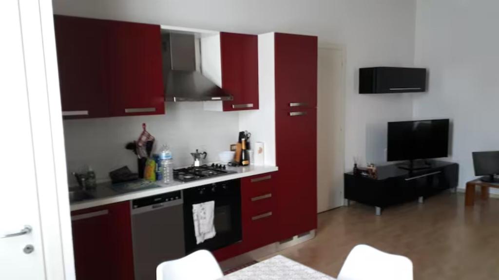 a kitchen with red cabinets and a stove at Lorenzo's House in Thiene