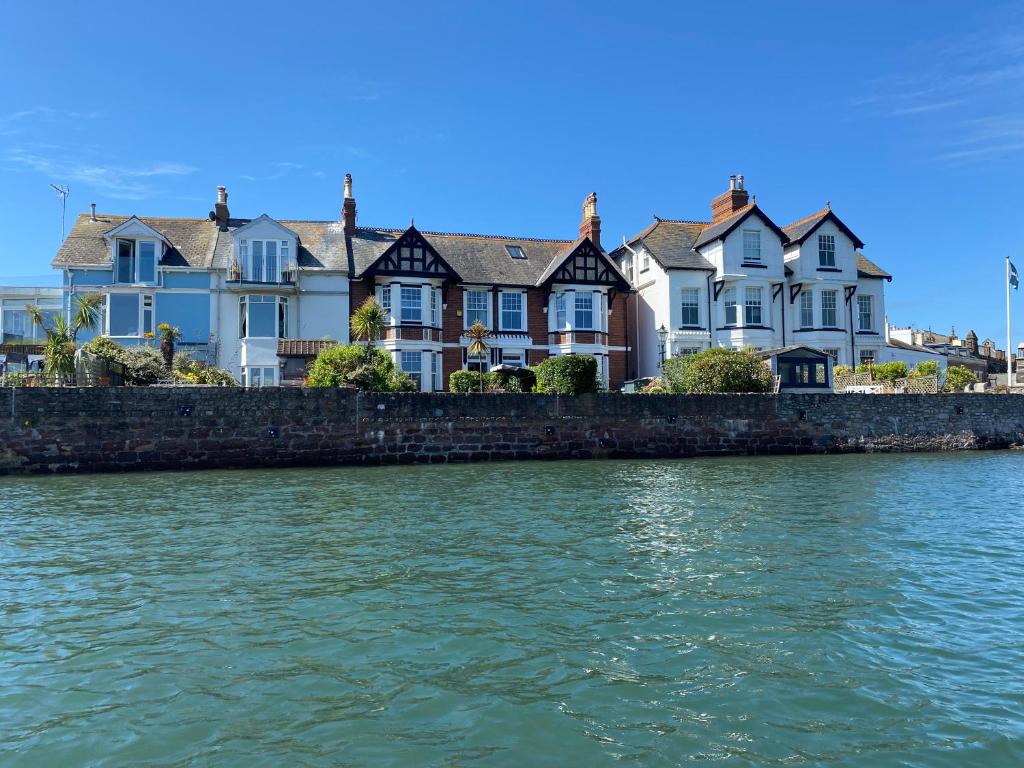 a row of houses next to the water at A unique and spacious river front property in Shaldon