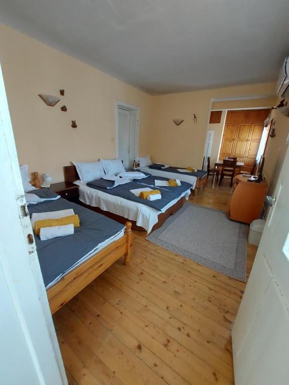 a room with three beds and a table and chairs at Вила Радеви in Obzor