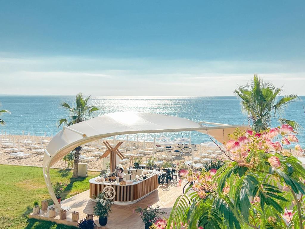 um restaurante na praia com o oceano ao fundo em Sentido Marea Hotel - 24 hours Ultra All inclusive & Private Beach em Golden Sands