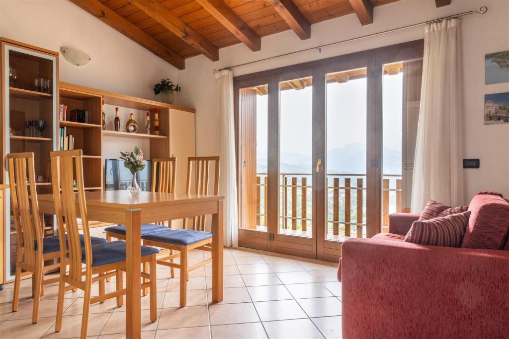 ein Esszimmer mit einem Tisch und einem Balkon in der Unterkunft IseoLakeRental - La Magia del Lago in Ranzanico