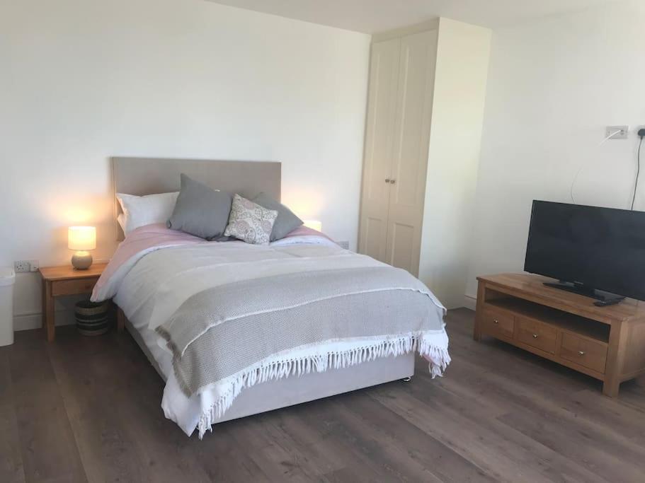 a bedroom with a bed and a flat screen tv at New studio near Lahinch, Doolin & Cliffs of Moher in Lahinch