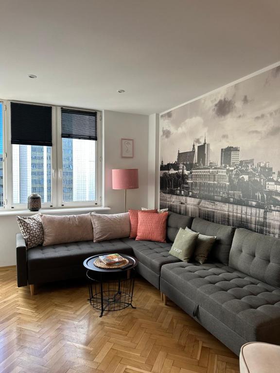 a living room with a couch and a large painting at Apartament Centrum Warszawy in Warsaw