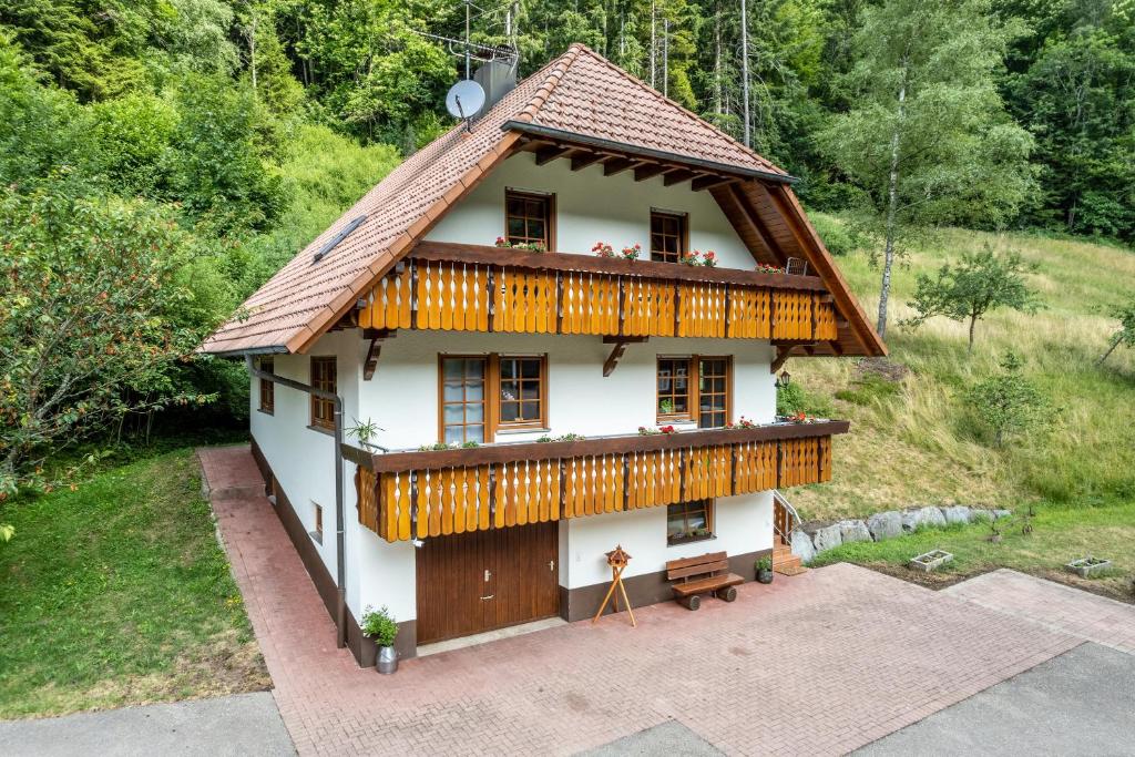 a small white house with a wooden roof at Ferienhaus Gießler in Nordrach