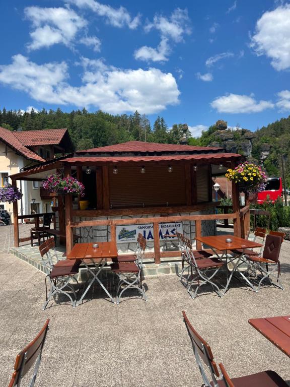 eine Terrasse mit Tischen und Stühlen und ein Gebäude in der Unterkunft Jamas Hotel & Restaurant in Pottenstein